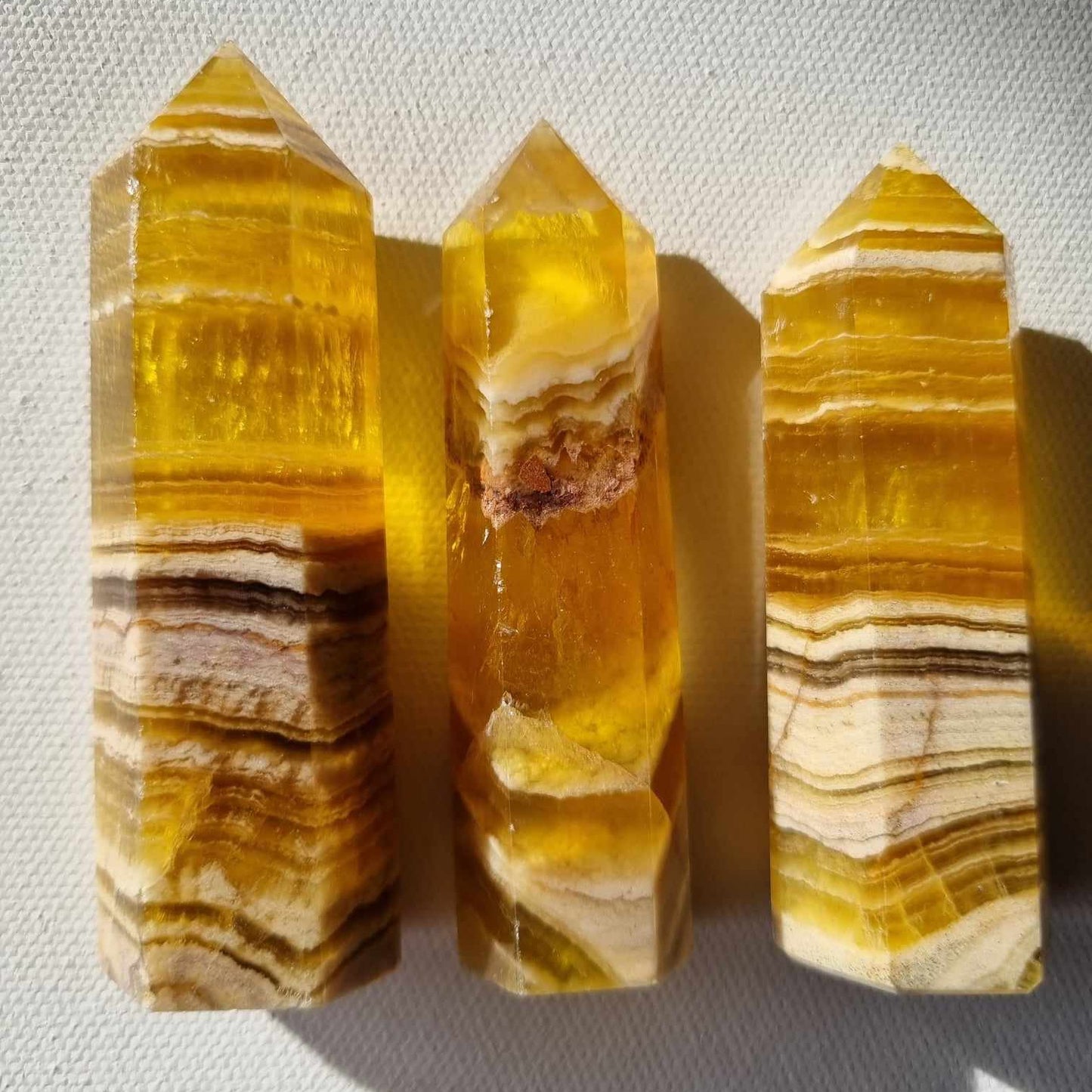 Three yellow crystal points on a textured gray background