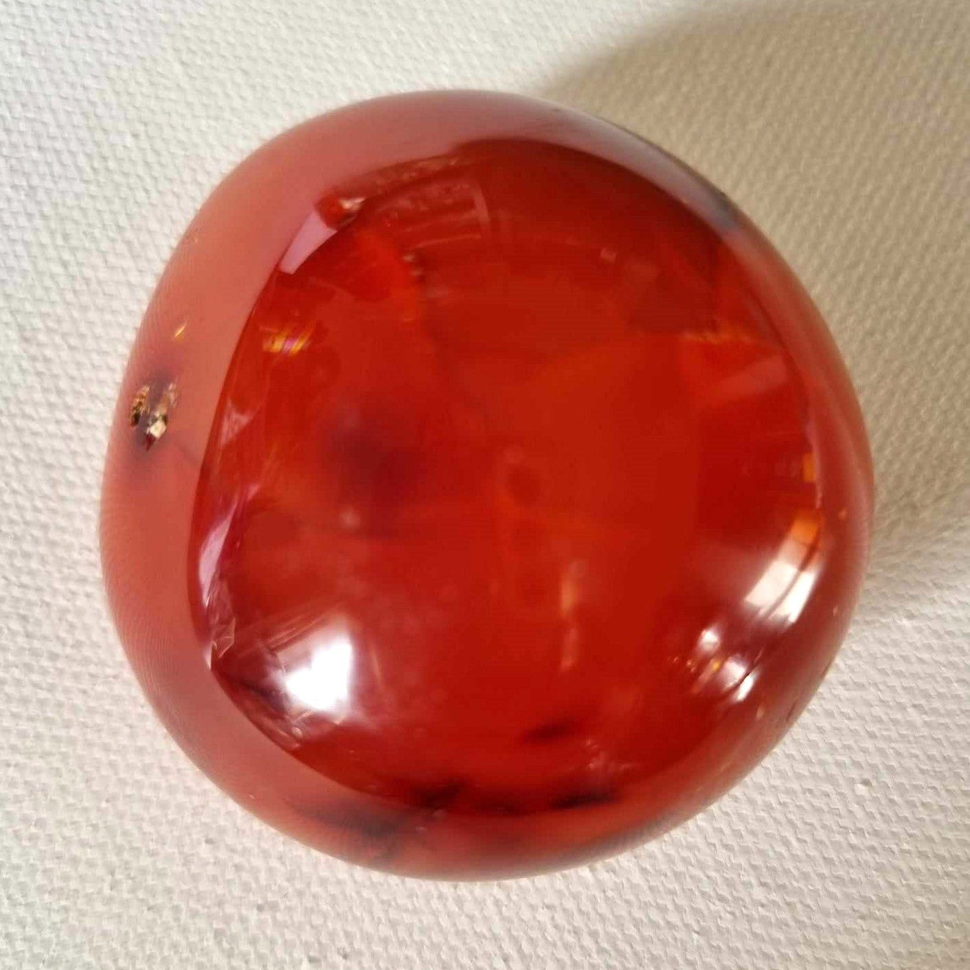 Red orange stone on a textured white background