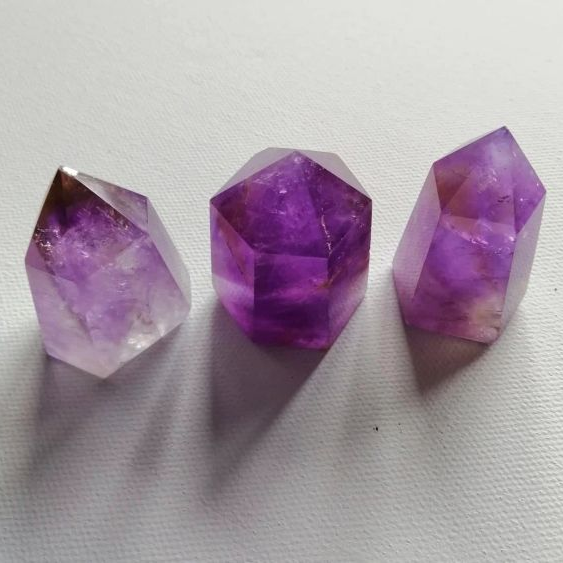 Three purple crystal points on a white background