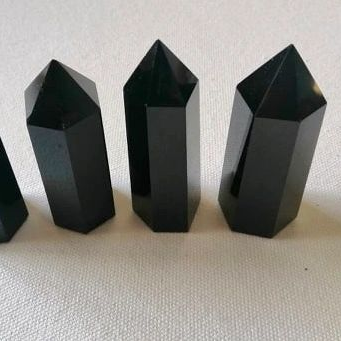 Three black crystal points on a light gray background