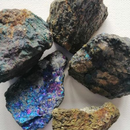 Collection of raw, multicolored rocks on a white background