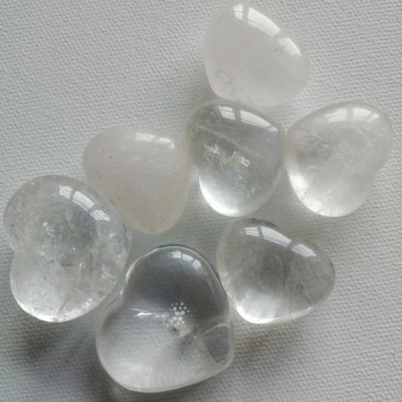 Clear crystal heart-shaped stones on a gray background