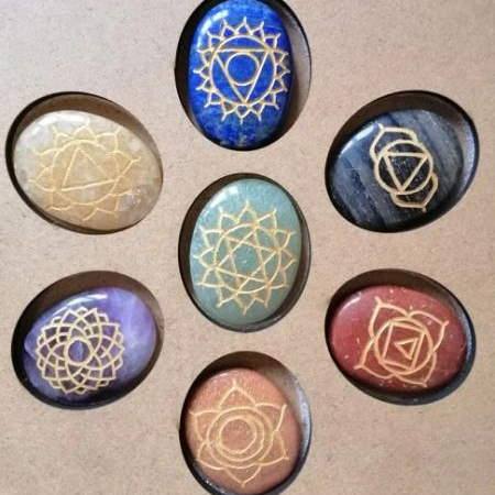 Set of seven stones with symbolic designs on a cardboard backing