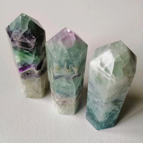 Three crystal points on a light gray background