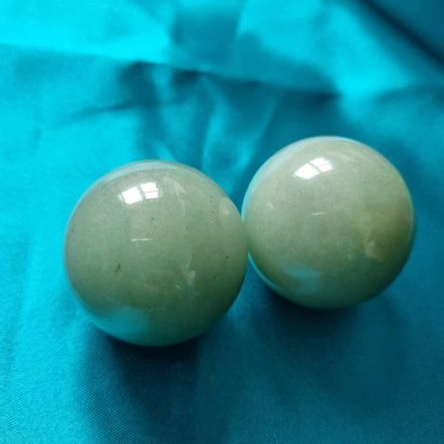Two green orbs on a blue fabric background