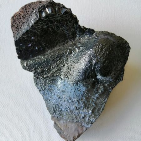 Raw Hematite piece with a textured surface on a white background