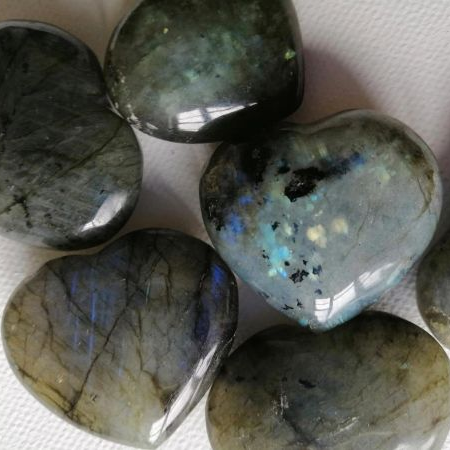 Close-up of polished labradorite hearts on a white background