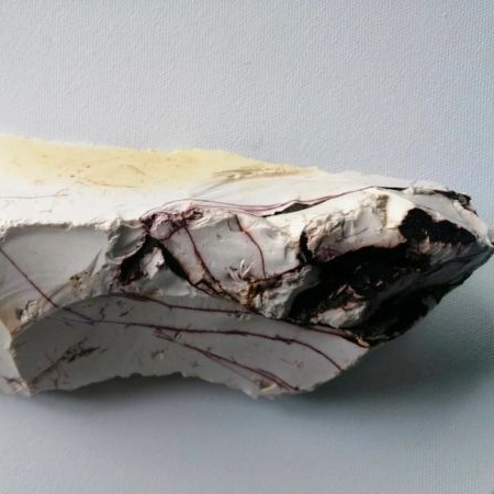 Raw Mookaite on a gray background