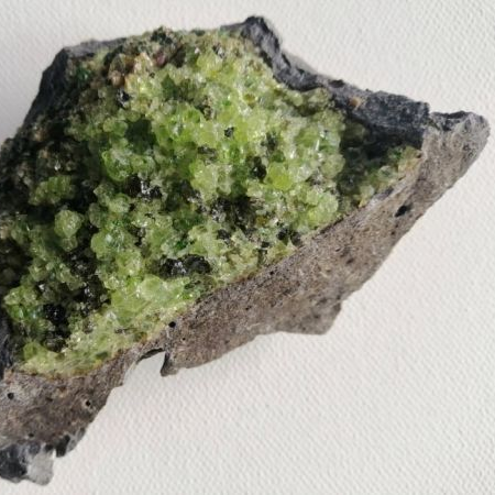 Raw Olivite piece on a white background