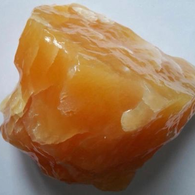 Raw orange calcite on a white background