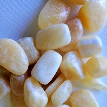 Orange calcite tumble stones on white background