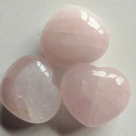 Three pink crystal hearts on a light gray background