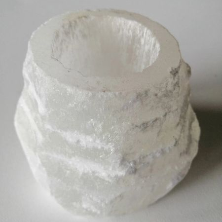 Selenite layered tealight candle holder on a light gray background