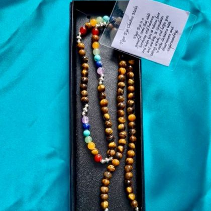 Colorful beaded necklace in a black box on a blue background