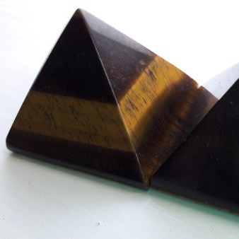 Tiger's eye crystal pyramid on a white background