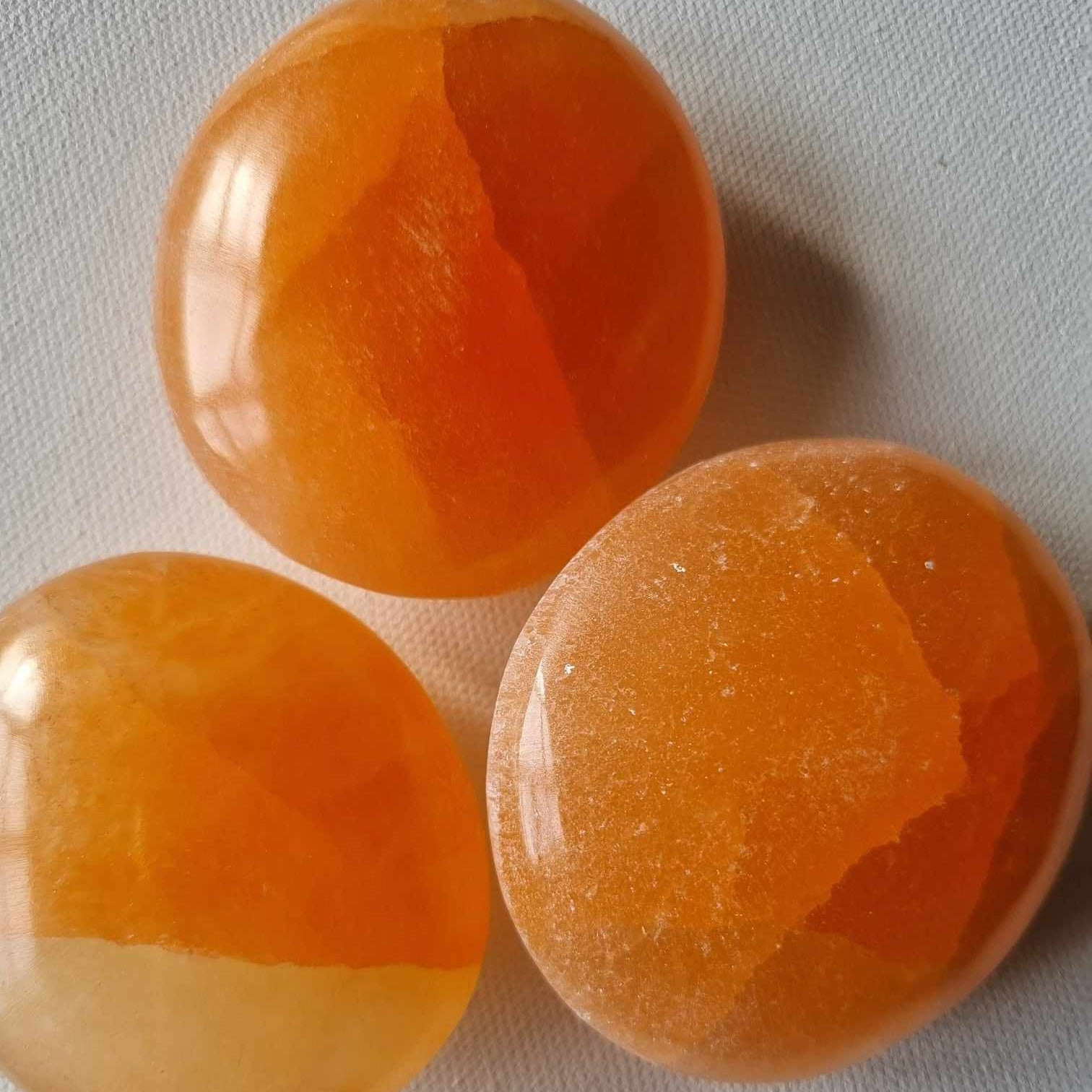 Three orange stones on a light gray background