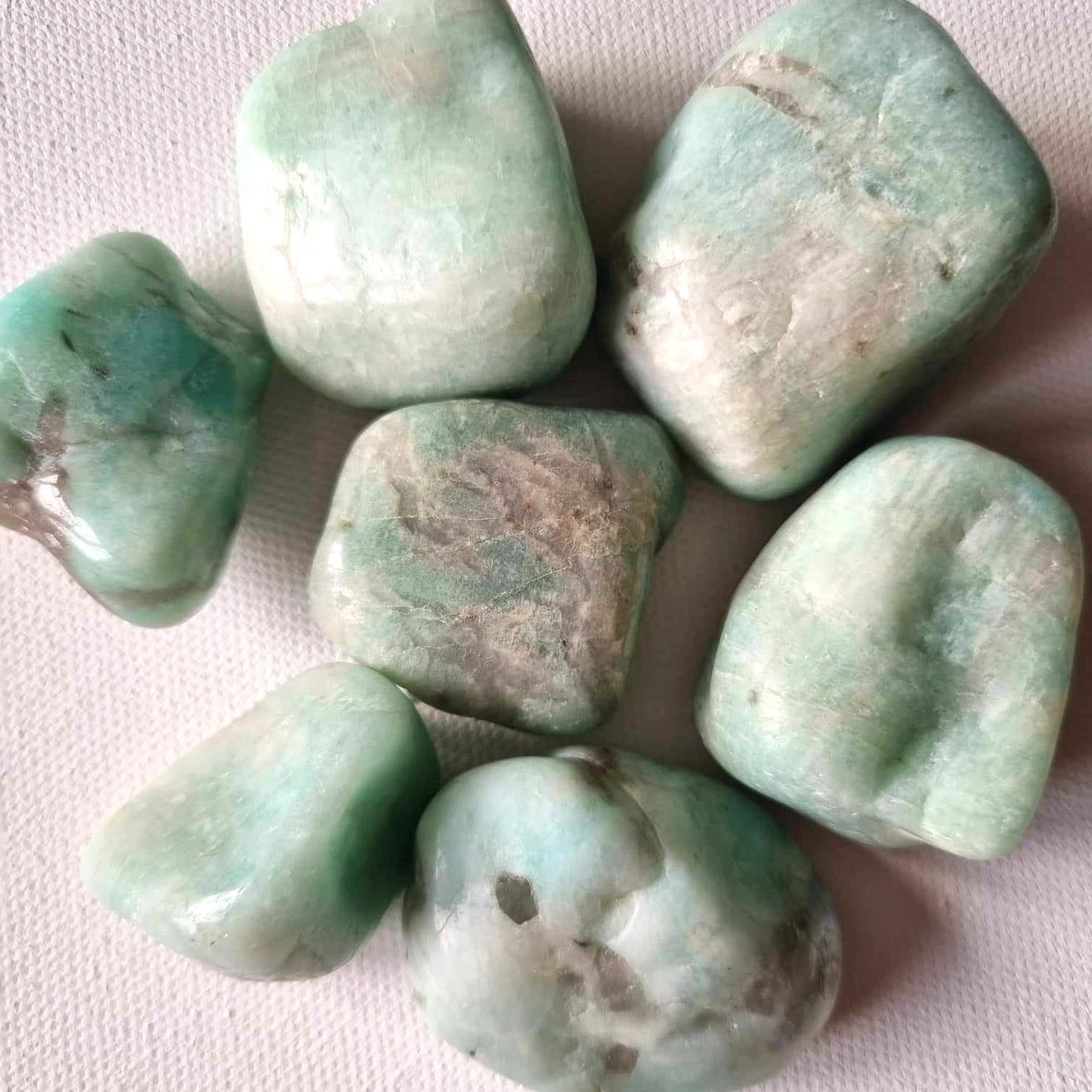 Collection of greenish-blue stones on a light pink background