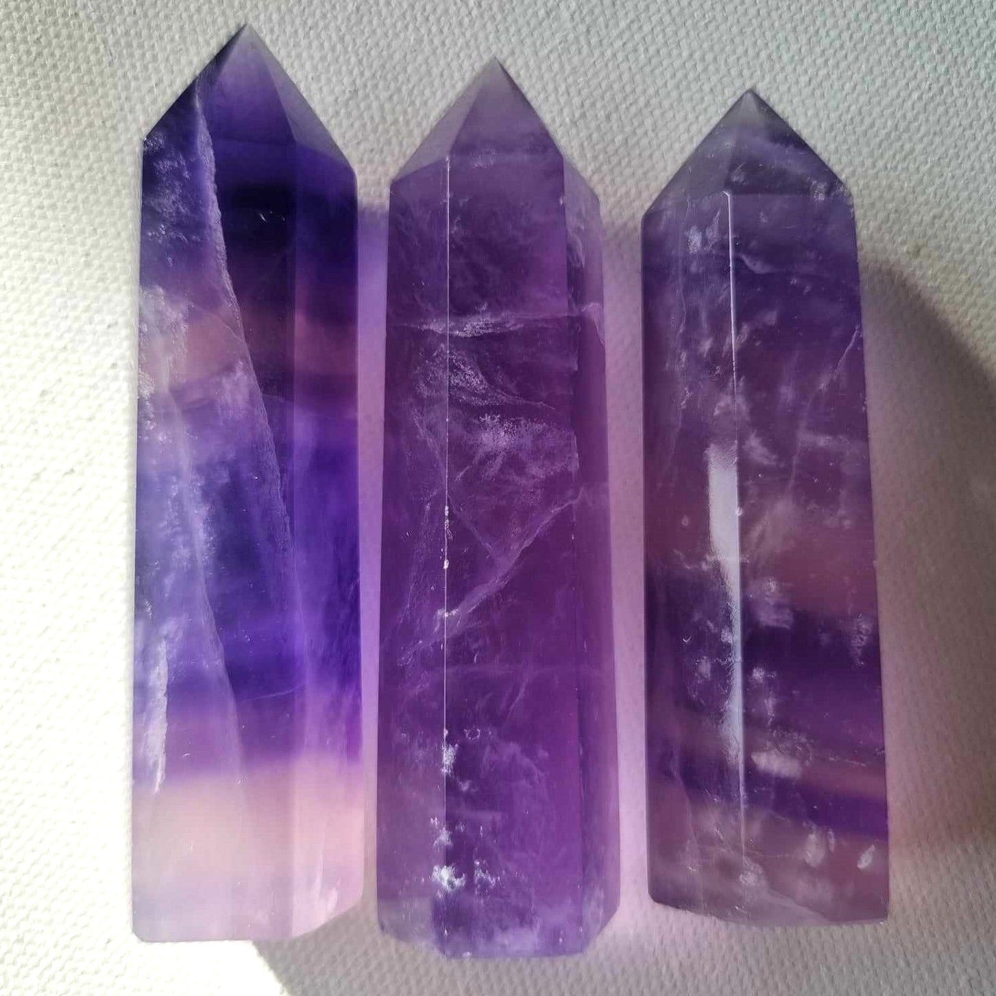 Three purple crystal points on a light gray background