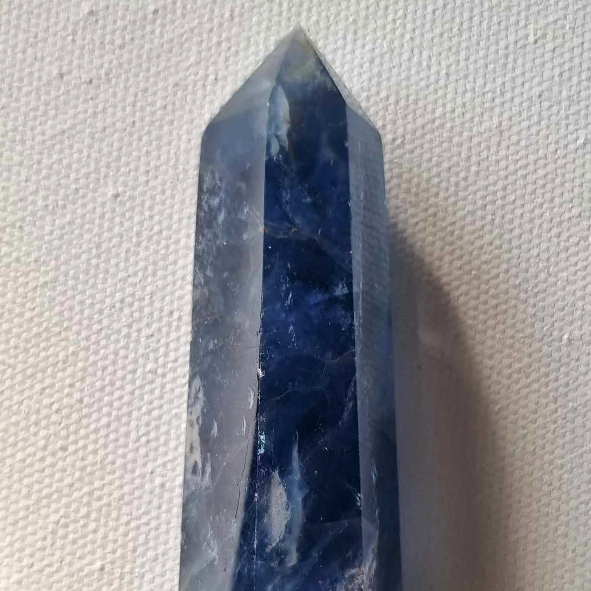 Blue crystal point on textured background