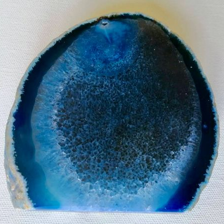 Geode slice with blue and black interior on a white background