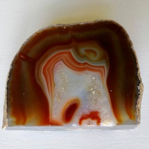 Agate stone with brown, orange, and white patterns on a white background