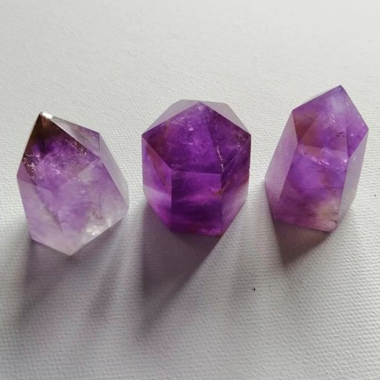 Three purple crystal points on a white background