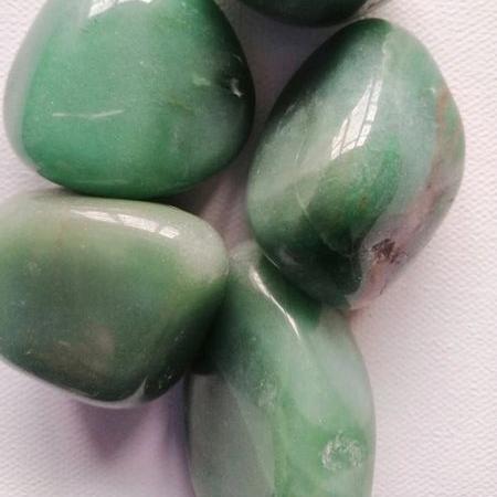 Four green stones on a white background
