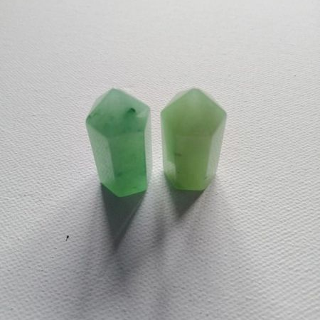 Two small green crystal points on a white background
