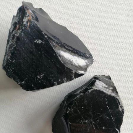 Two rough black stones on a light gray background