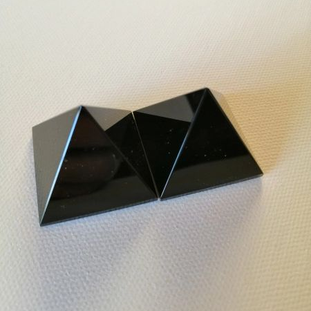 Black pyramid-shaped crystals on a textured white surface
