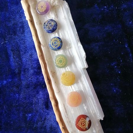 Set of chakra stones on a crystal with a blue textured background
