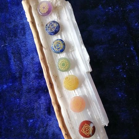 Set of chakra stones on a crystal with a blue textured background