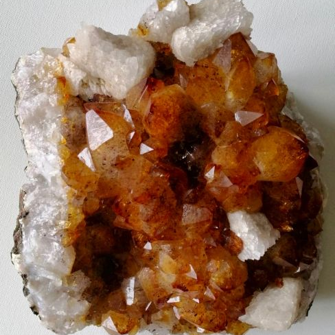 Mineral sample with orange crystals on a white background