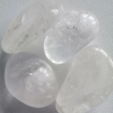 Three clear crystal stones on a textured gray surface