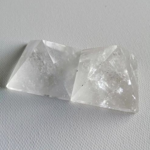 Two crystal pyramid shapes on a light gray background