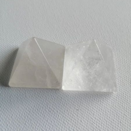 Two white pyramid shaped pieces on a textured gray surface