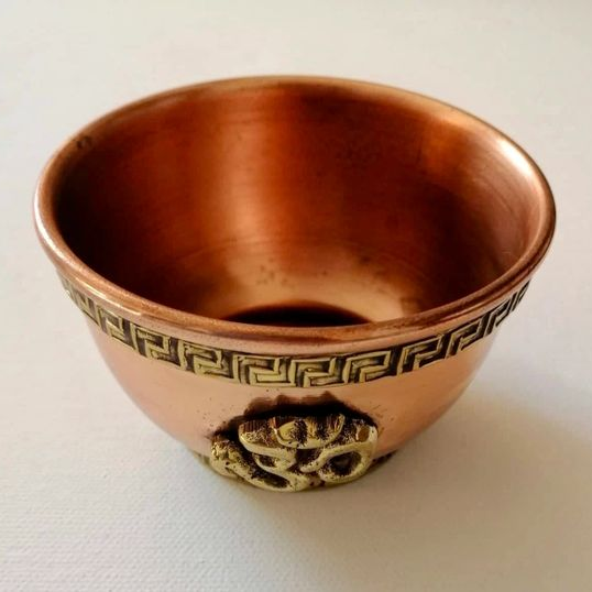 Copper bowl with decorative patterns on a white background
