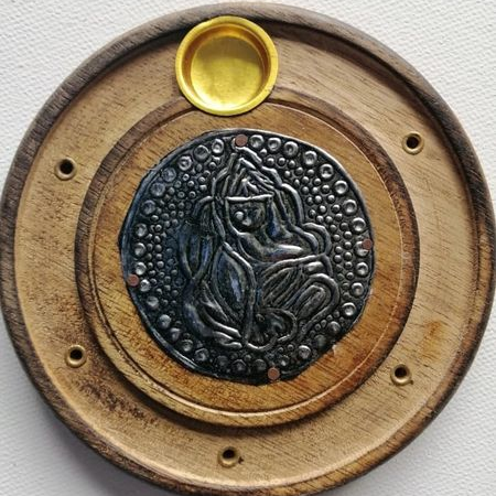 Decorative incense holder with wooden border, metallic center, and embossed design on a white background