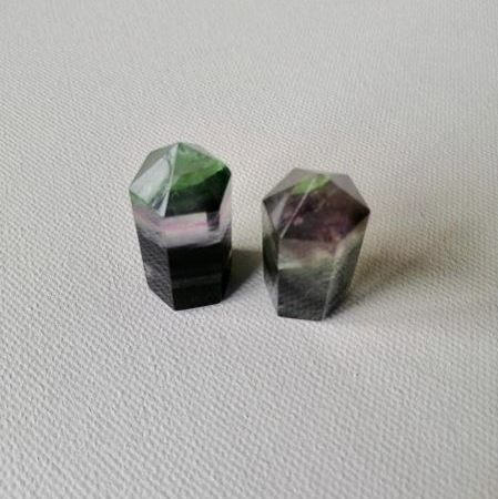 Two small faceted points on a light gray background