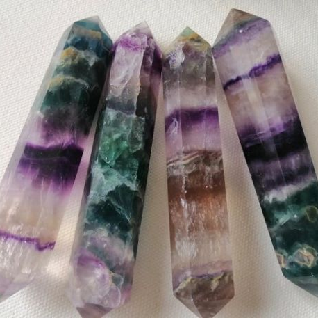 Four crystal wands with colorful patterns on a white background