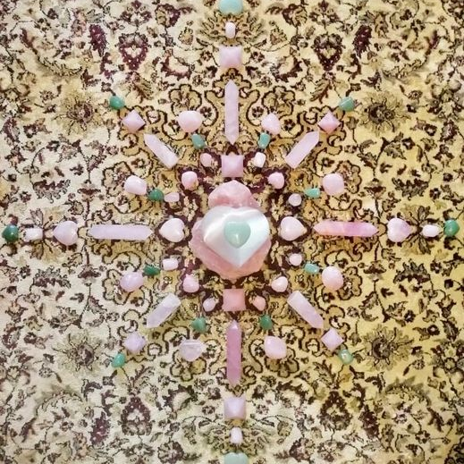Grid of pink and green crystals on a textured fabric background