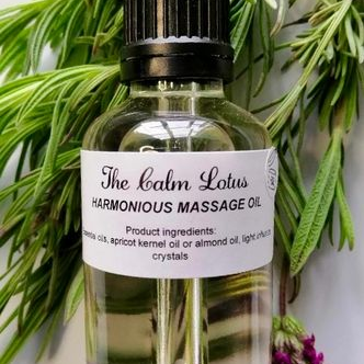 Bottle of 'The Calm Lotus' harmonious massage oil with a dropper, surrounded by greenery and flowers.