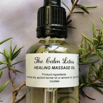 Bottle of 'The Calm Lotus' healing massage oil with a dropper on a light background with greenery.