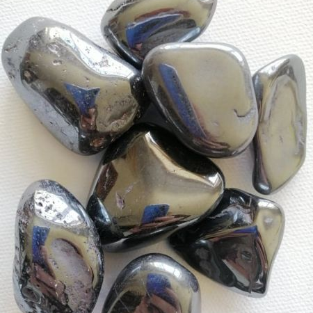 Shiny metallic Hematite tumble stones on a white background