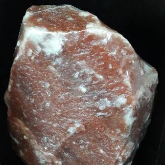Red Himalayan salt lamp on a dark surface