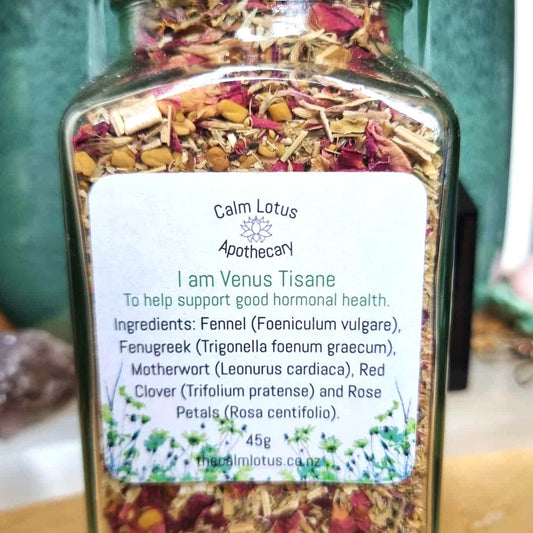 Jar of Calm Lotus Apothecary I am Venus Tisane with a label on a wooden surface.