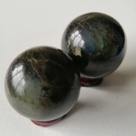 Two Labradorite orbs on a white background