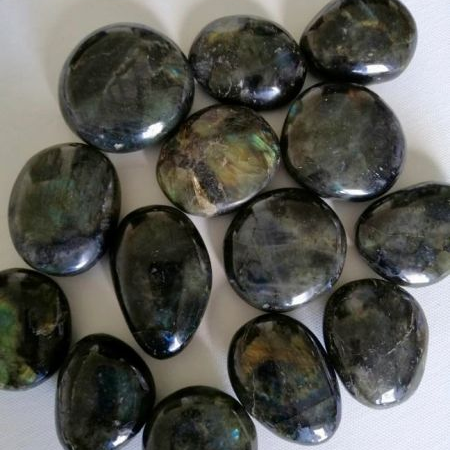 Collection of polished labradorite stones on a white background
