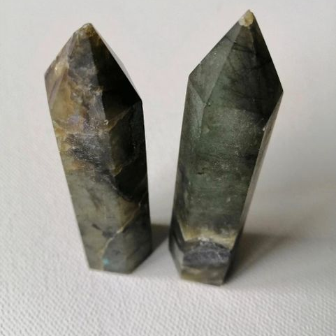 Two Labradorite crystal points on a white background