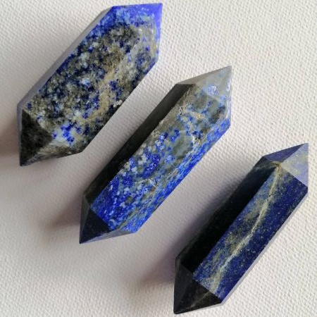 Three lapis wands on a white background